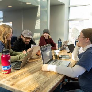 Photos of students on their laptops at a table.